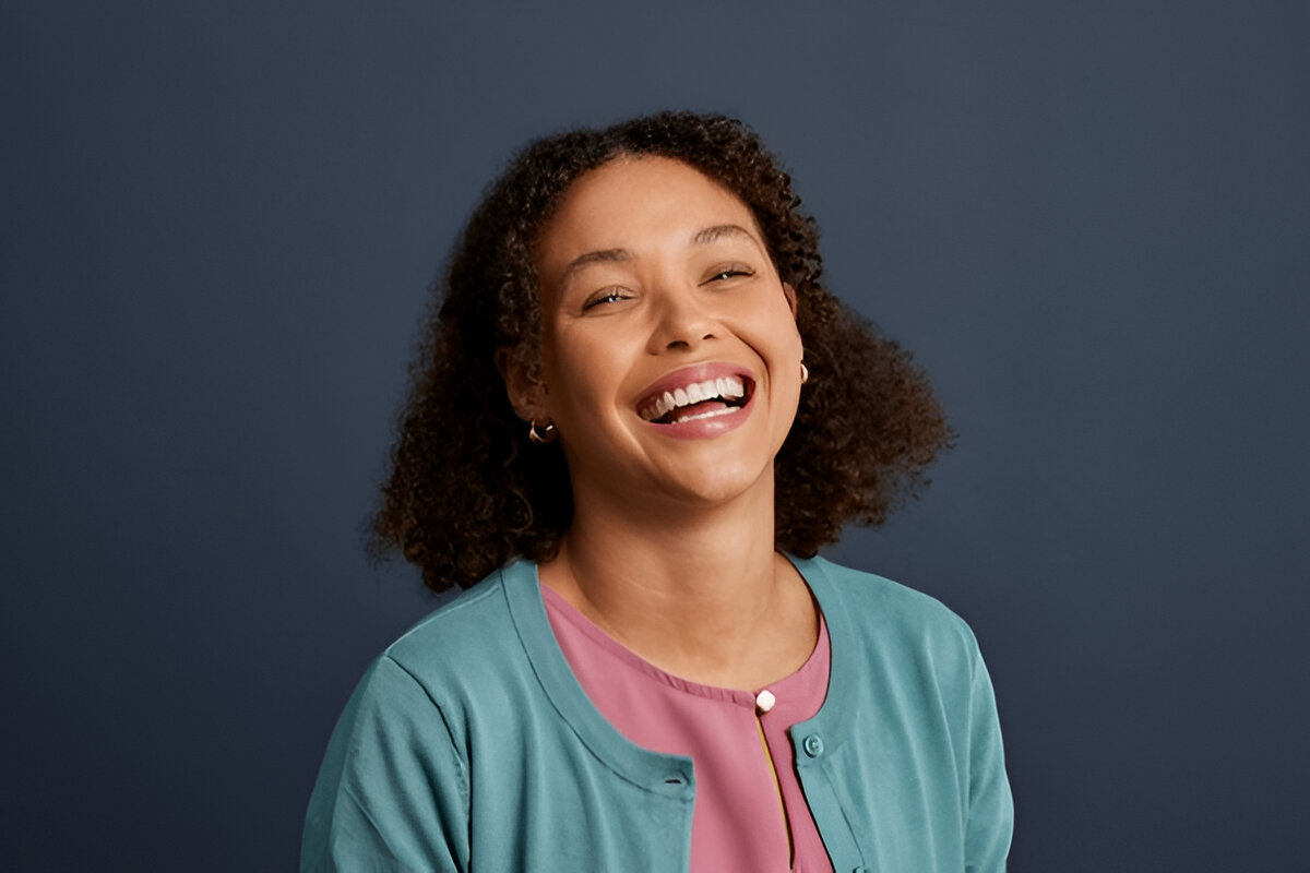 A woman proudly displaying her bright smile after treatment at Bright Dental.