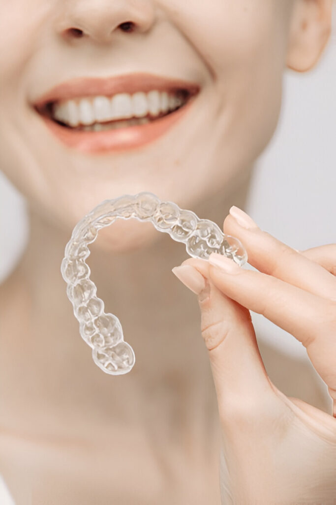 Girl holding Invisalign clear aligners at Bright Dental